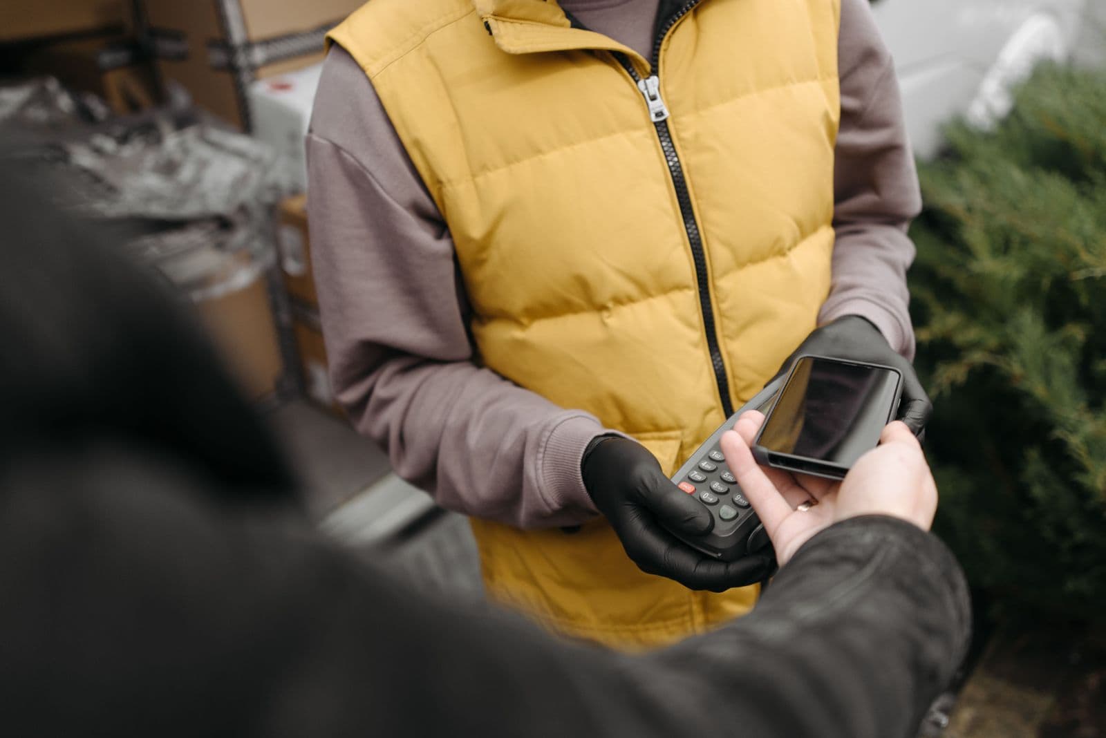 A courier confirming a job on a handheld terminal at the kerbside
