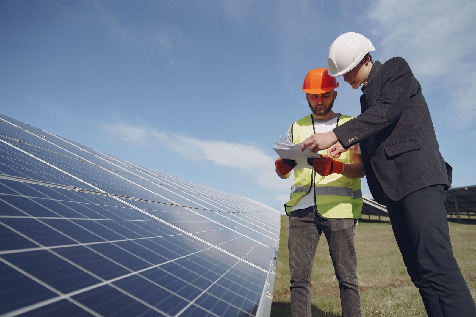 A supervisor and a technician reviewing documentation together on site