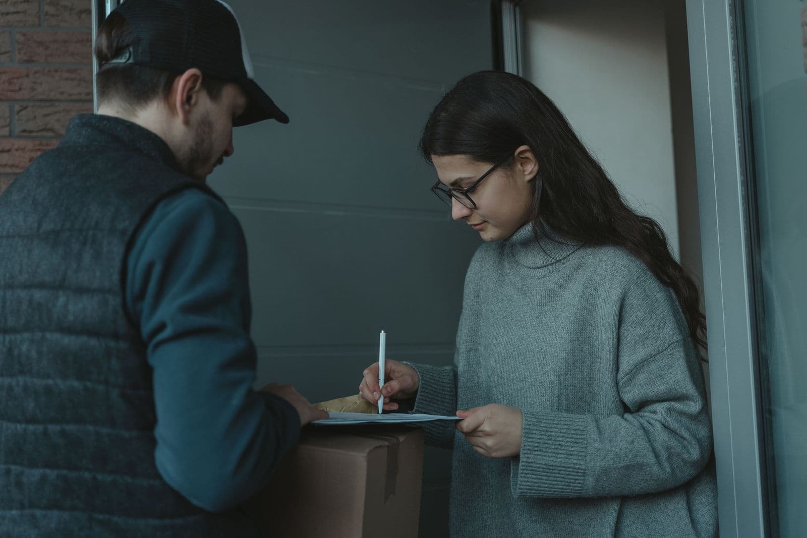 A customer signing for a parcel handed over at their front door