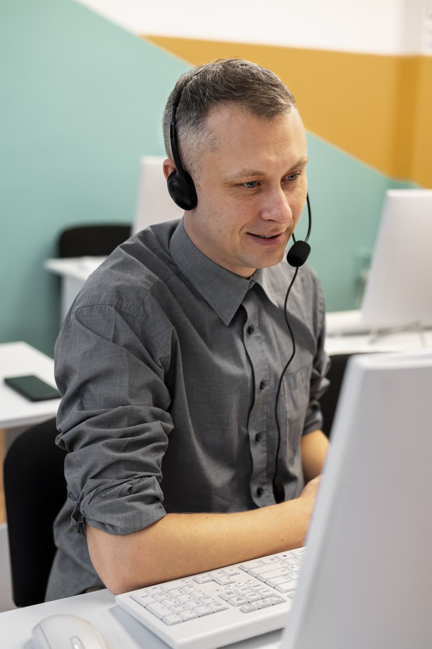 A dispatcher wearing a headset working at a computer